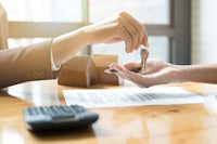 a person handing over keys to a house to another person